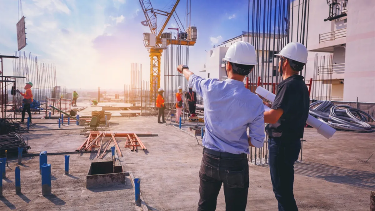 MEP estimating services: contractors reviewing building plans on an active construction site